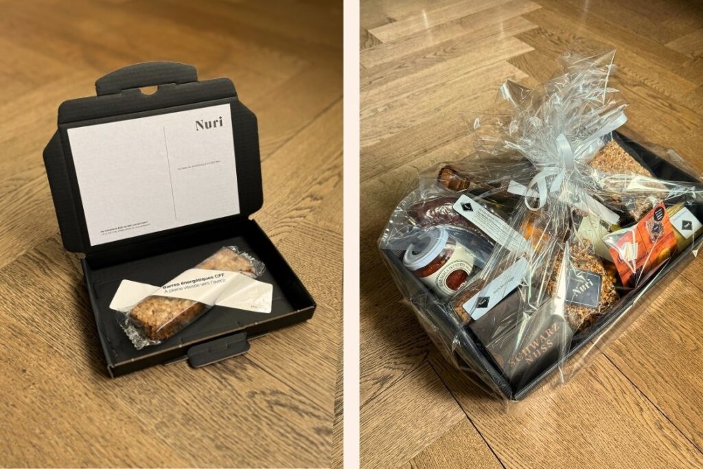 Nuri Muesliriegel in einer schwarzen Verpackung als Geschenk und einen verpackten voll gefüllten Geschenkkorb für ein Firmengeschenk